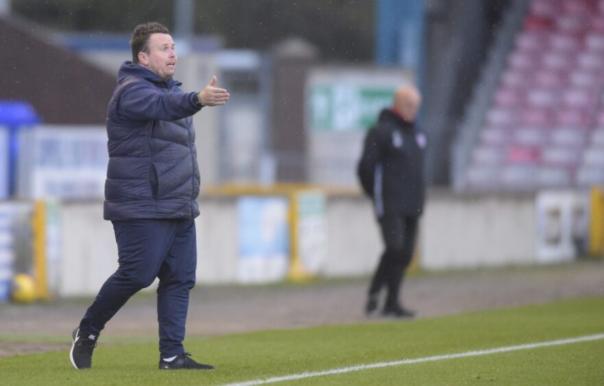 Inverness head coach Scott Kellacher points to his players from the sidelines.