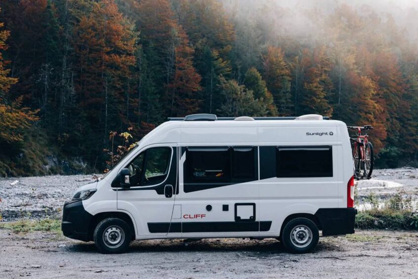 campervan in front of woodlands