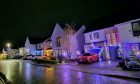 Residential street covered in Christmas lights.