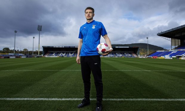 Inverness Caledonian Thistle midfielder Charlie Gilmour poses with a football in his left hand within the Caledonian Stadium, Inverness.