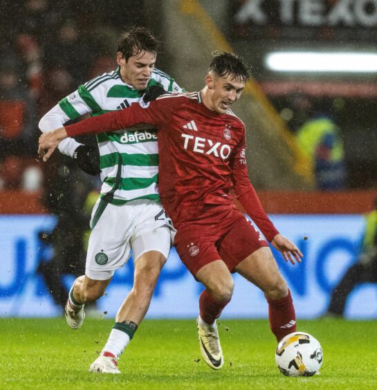 Aberdeen midfielder Jamie McGrath hold out his right arm to shield the ball from Celtic's Paulo Bernardo in the 1-0 loss at Pittodrie. Image: SNS