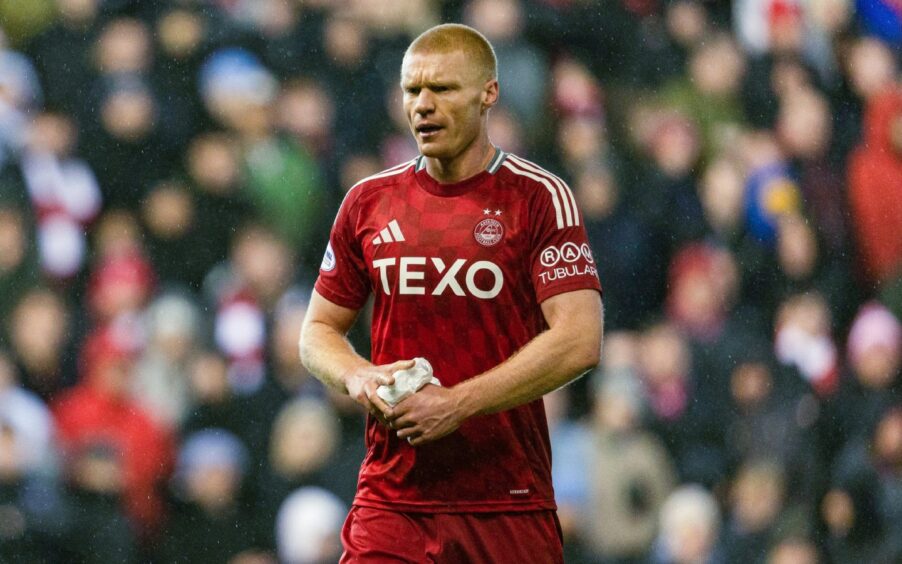 Aberdeen midfielder Sivert Heltne Nilsen dries his hands in a match against Celtic