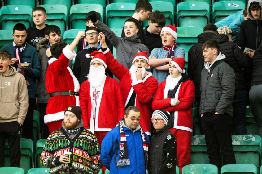 Ross County fans get into the festive spirit, with many wearing Christmas attire at Easter Road Stadium, Edinburgh, with some in Santa suits. 