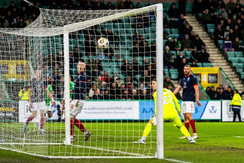 Hibs forward Dwight Gayle scores with a glancing header to make it 1-1, with Ross County goalkeper Jack Hamilton rooted to the spot. 