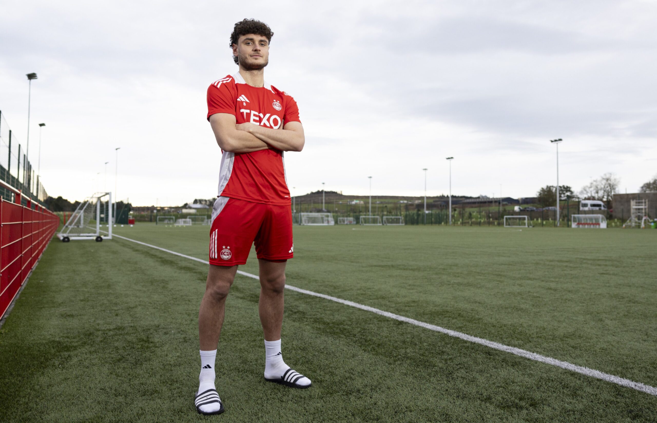 Aberdeen midfielder Dante Polvara at the club's Cormack Park training facility with an all weather pitch behind him. 