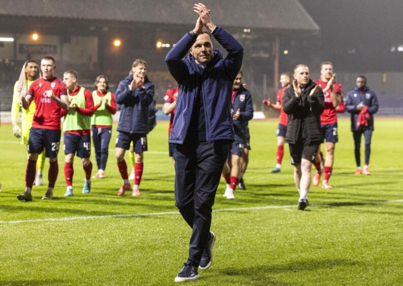 Ross County manager Don Cowie and his players celebrate their 3-0 SPFLPremiership win at Dundee with the fans. Cowie has his hands in the air, applauding his team's supporters at full-time, with his players and staff doing likewise behind him at Dens Park, Dundee, on December 26, 2024. 