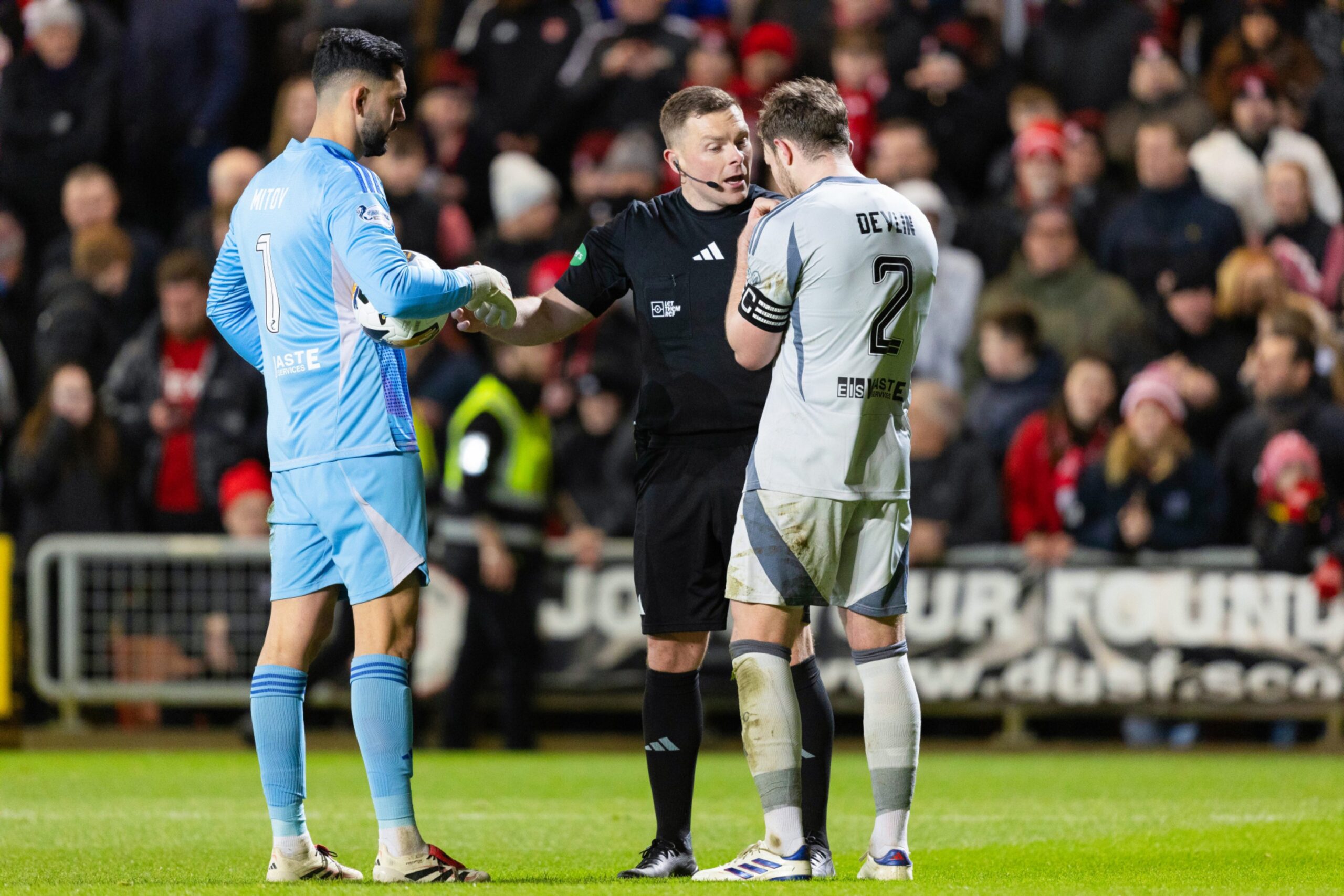 Aberdeen's Nicky Devlin (R) and Dimitar Mitov remonstrate with Referee John Beaton in the 1-0 loss to Dundee United. 