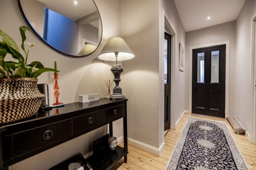 Stylish hallway with lamps and wooden flooring at this Mannofield property