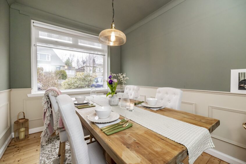 Dining room with wooden panelling on the walls and wooden floors at this Mannofield property