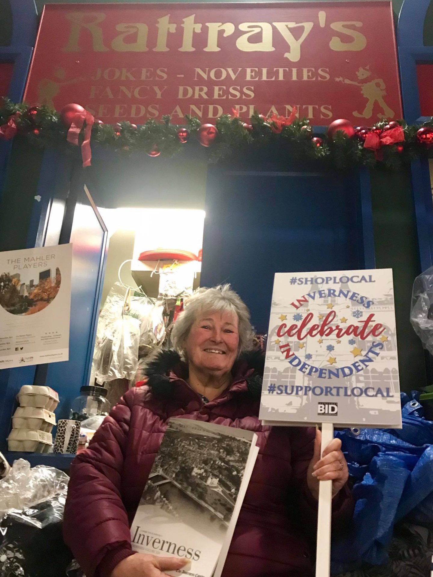 Nancy Rattray holding a shop local sign 