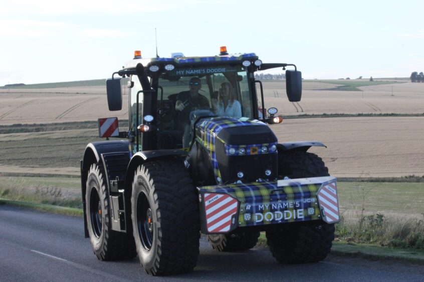 Sandy Duffus driving the Doddie Weir Fastrac in the tractor run, with Kim Tedcastle as passenger.