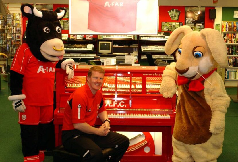 Aberdeen assistant manager Duncan Shearer, Angus the Bull and Magic the Bunny belt out the Northern Lights on a 1930s piano which was rebranded in AFC colours. 