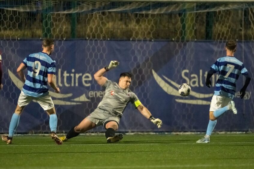 Keith goalkeeper Craig Reid, centre, dives to save a shot from Andy Hunter of Banks o' Dee, left.