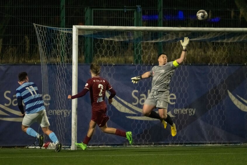 Max Alexander, left, of Banks o' Dee watches his header loop over Keith goalkeeper Craig Reid, right.