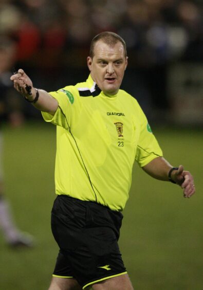 Craig Mackay points for a free-kick while refereeing a match