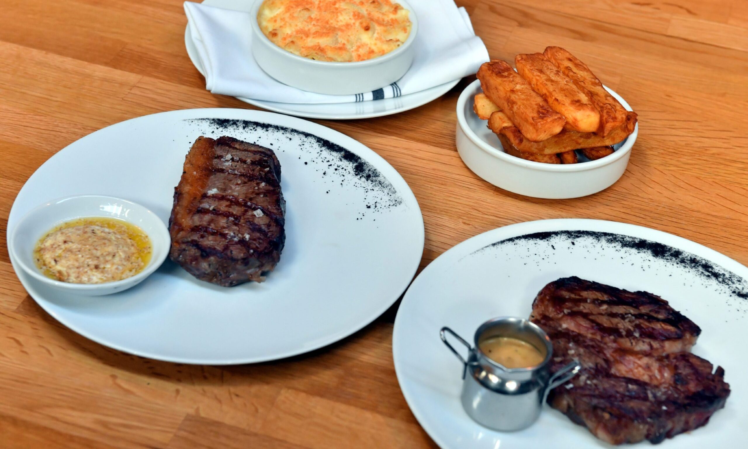 Steak dishes are served with sides like chunky chips and macaroni cheese at the restaurant