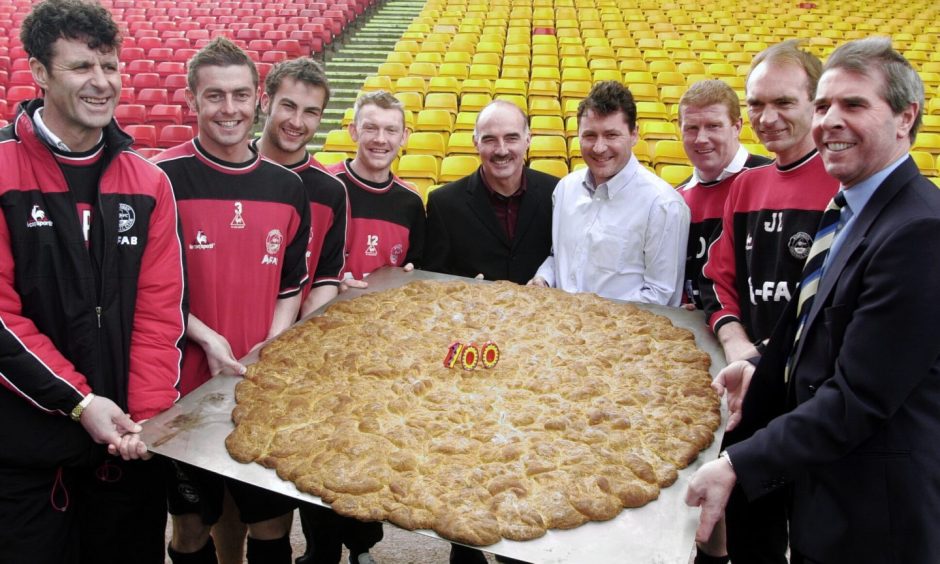 How else would you celebrate 100 years of Aberdeen Football Club than with a giant rowie/buttery/roll. Pictured holding it are, from left on 14 April 2003, Steve Paterson, Jamie McAllister, David Preece, Steve Tosh, Willie Miller, Jim Bett, Duncan Shearer, Jim Leighton and Jim Whyte.