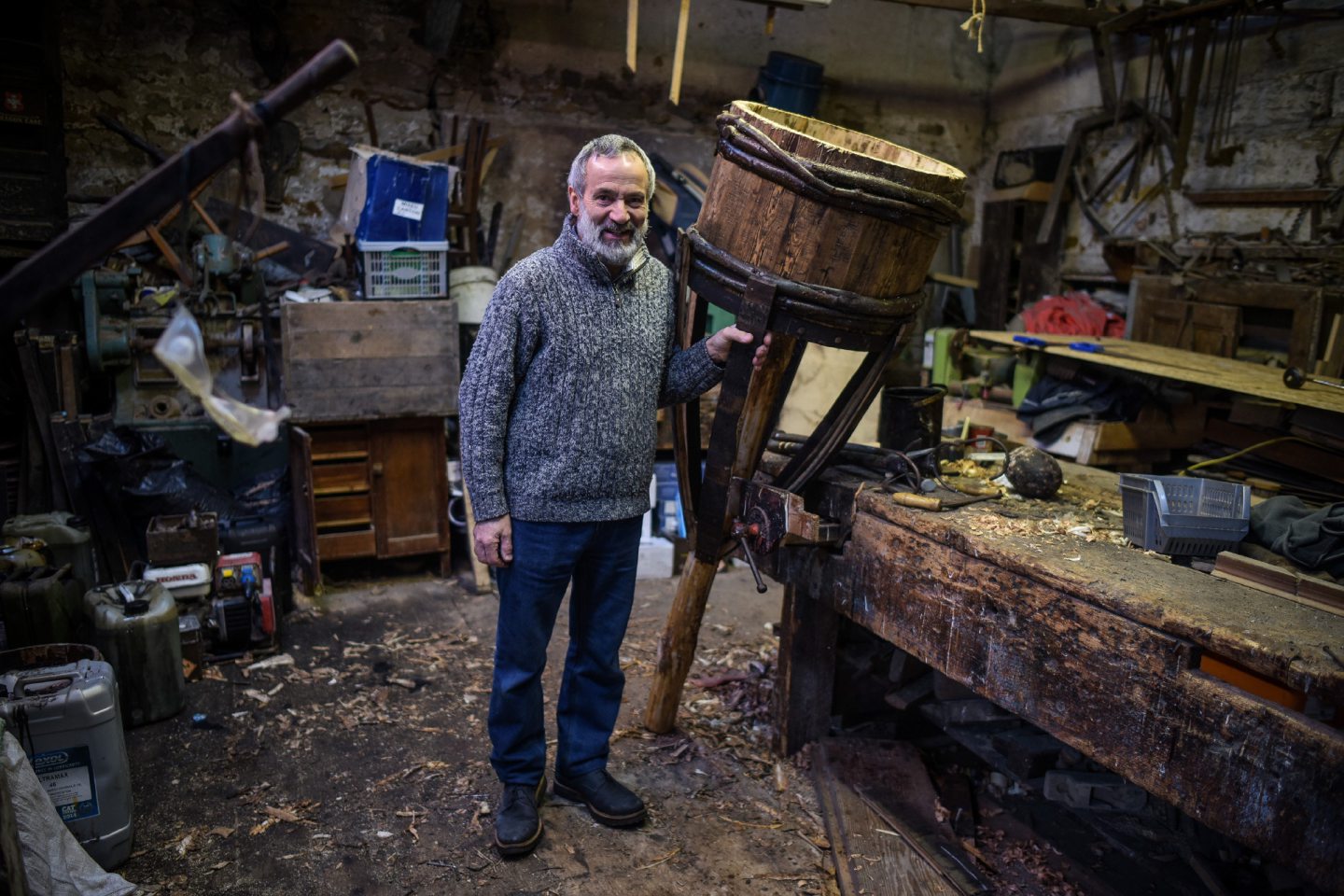 Dan Ralph holding up the empty clavie in a workshop.