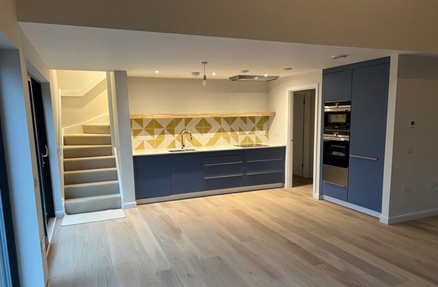 A new fitted kitchen with patterned tiles and grey cupboards