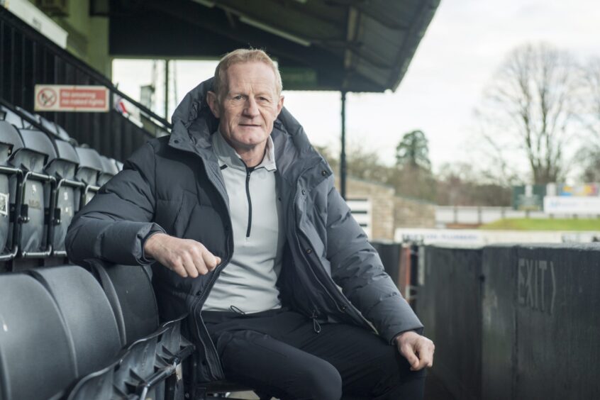 Colin Hendry pictured at Borough Briggs, Elgin, when visiting as part of the Football Memories tour last week. Colin is pictured sitting in the main stand, facing the camera. 