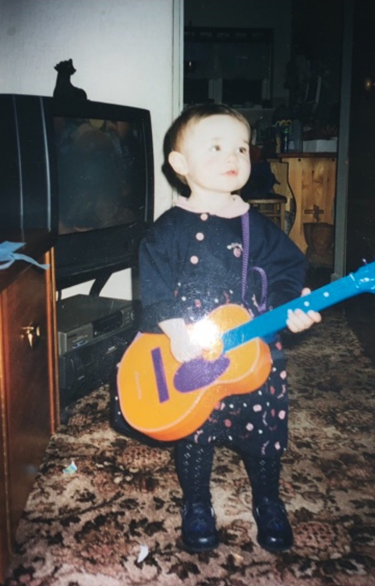 Jemma Ferries as a five-year-old with a toy guitar. 