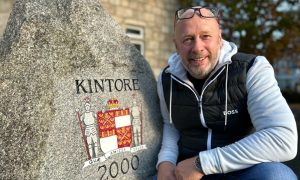 North East Scotland High Street Hero Jim Reid in front of the Millennium Stone and the Town House in Kintore, which he restored along with the coat of arms.