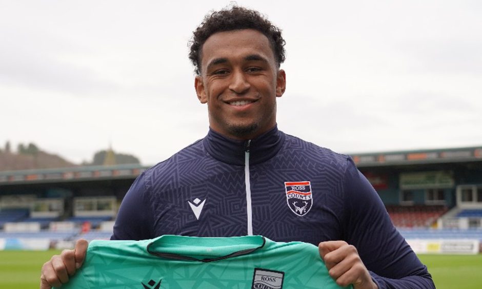 Goalkeeper Jordan Amissah with a Ross County jersey in hands after completing his short-term move to the Scottish Premiership club. 