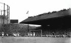 Scores of fans sit on the Pittodrie Stadium roof watching a match in the 1950s.