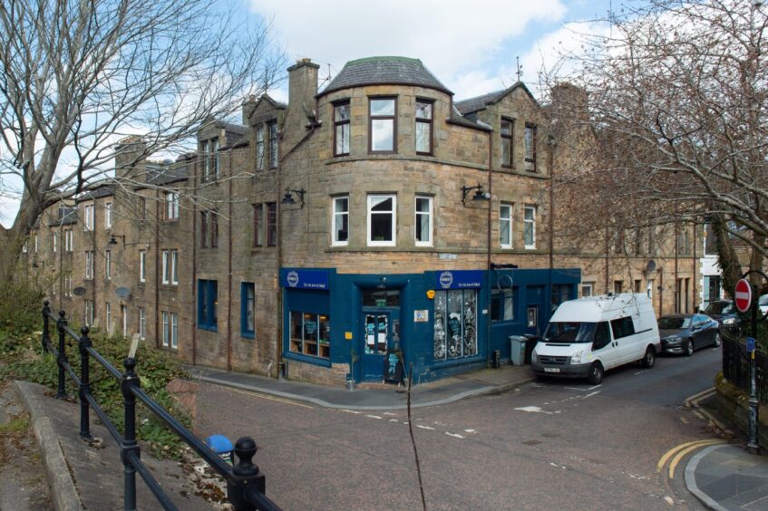 Distance shot of the blue facade of Velocity Cafe on a street corner.