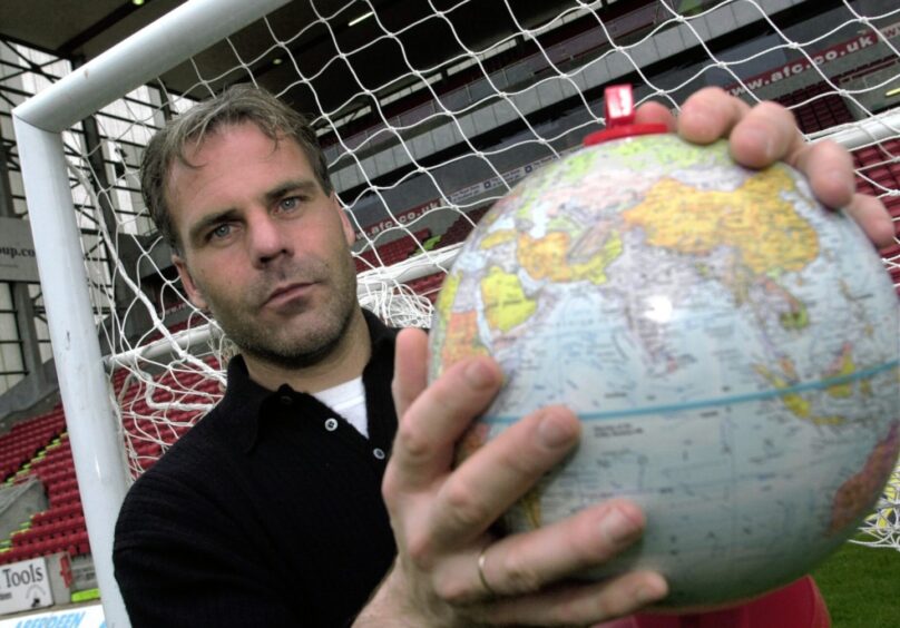 Aberdeen FC goalkeeper Peter Kjaer in the goalmouth at Pittodrie holding a globe 