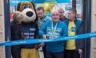 Poundland cutting the ribbon at door of Elgin store.