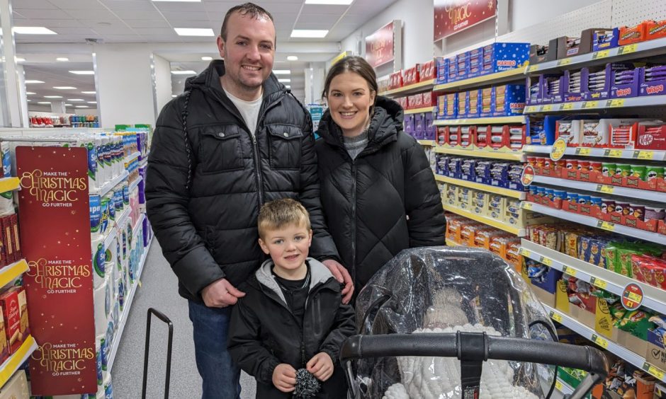 Family standing in Elgin Poundland. 