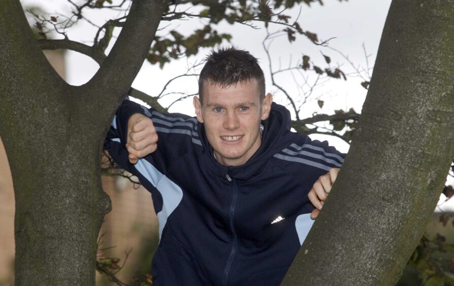 Zander Diamond climbing a tree while on Scotland under-21 duty.