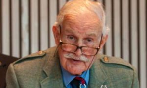 Sir Peter Graham wearing a green suit with his medals.