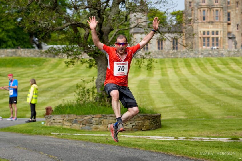 a runner jumping for joy at the Stornoway half marathon and 10k