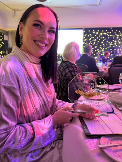 Susan Smart was light up in purple during an awards bash as she holds on to her award.