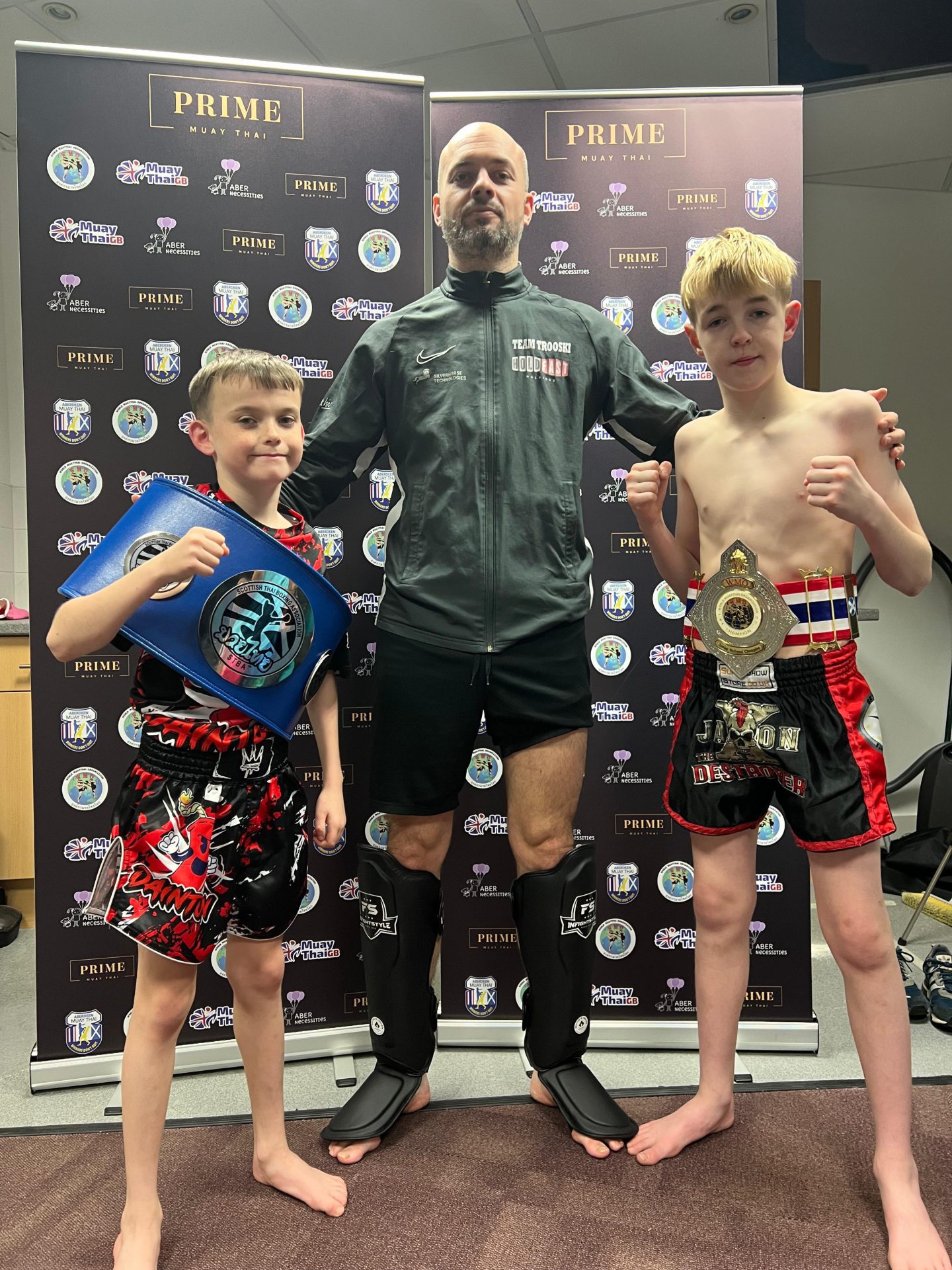 Jaxon Ritchie, right, with Aberdeen Muay Thai clubmate Dainton Love, left, and head coach Andrew Rose, centre, with their Scottish titles. Image: Ben Ritchie