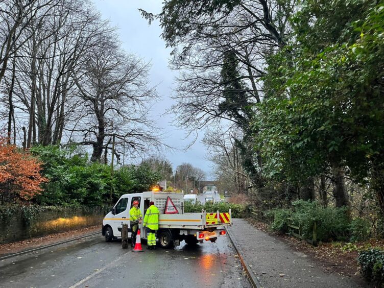 Workers in Stonehaven ahead of moving a tree over the road. 