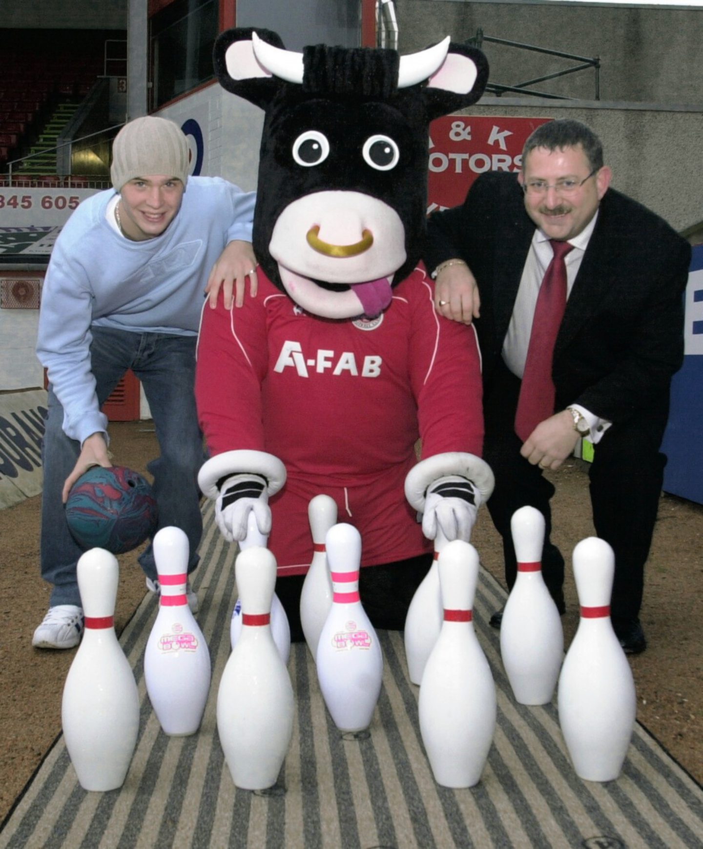 Dons striker Darren Mackie, Angus the Bull and Alan Tough, the general manager of Mega Bowl pose with some pins