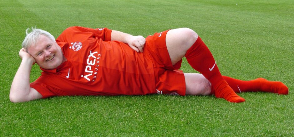 Aberdeen FC icon Joe Harper reclines on the Pittodrie pitch in full kit