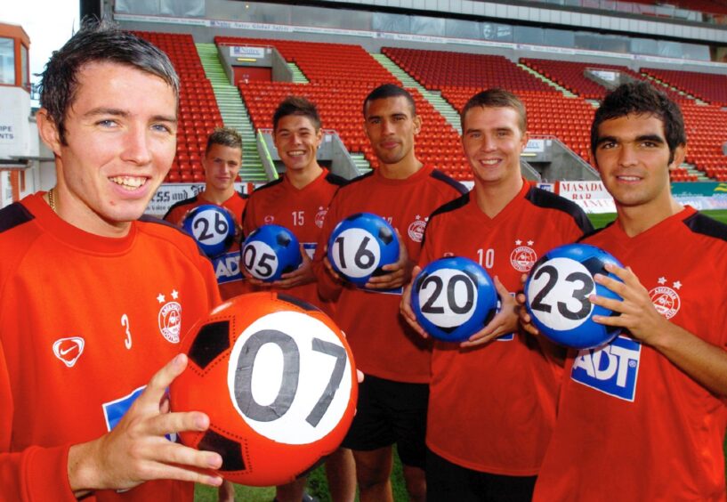 Aberdeen FC players lead the appeal to help find an Aberdeen person who won the Thunderball lottery. Pictured holding big lottery balls are from the front Kevin McNaughton, Andrew Bagshaw, Darren Mackie, Richie Byrne, Jamie Winter and Chris Maguire.