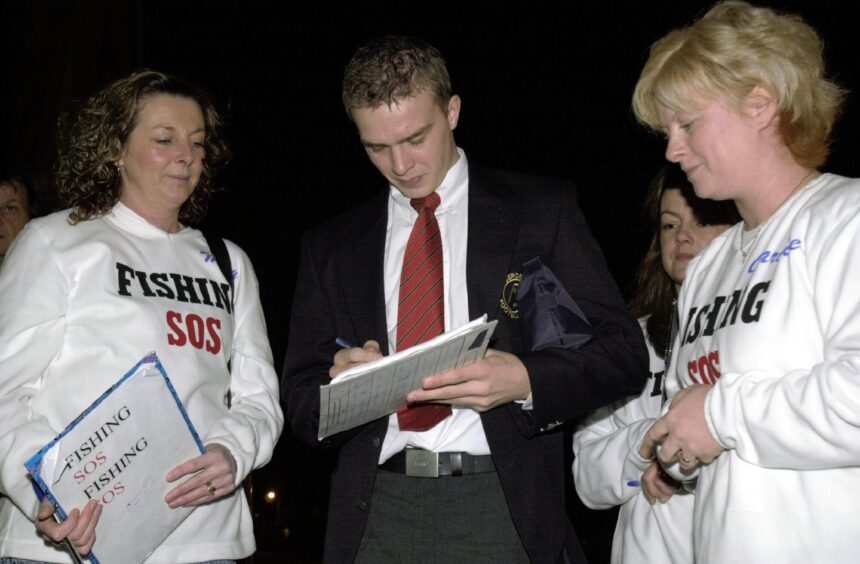 Darren Mackie signs the Cod Crusaders' petition for Morag Ritchie (left) and Caroline Bruce outside Pittodrie before a game against Kilmarnock. Image: Colin Rennie/DC Thomson.