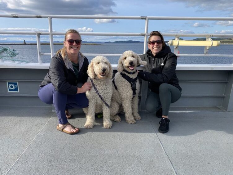 Kendal Daly and Stephanie Neeson with dogs Luna and Ziggy by the sea