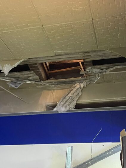 The hole created by thieves during a break-in at the Inverness newsagent.