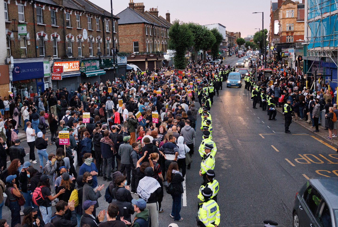 Police surround a 'refugees are welcome' protest near the offices of an immigration help centre in North Finchley in London. 