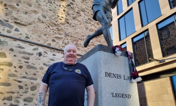 Jim Glendinning from Kirriemuir was among those paying their respects at the Denis Law statue. Image: DC Thomson