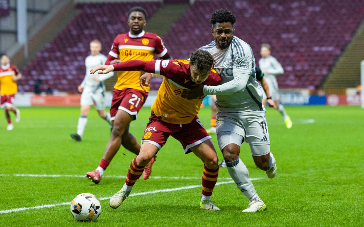 Motherwell's Davor Zdravkovski (C) and Aberdeen's Duk in action at Fir Park. Image: SNS 