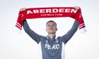 Kristers Tobers holds aloft an Aberdeen scarf. Image: SNS.