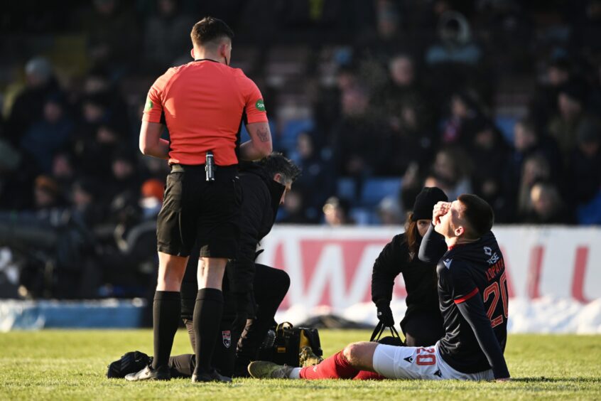 Ross County defender Kacper Lopata receives treatment for a groin injury sustained in his side's 4-1 SPFL Premiership defeat to Celtic at the Global Energy Stadium, Dingwall, on Saturday, January 11, 2025. 