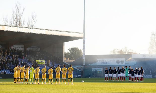 Ross County and Livingston players line up for a minute's silence ahead of Saturday's game. It was disrupted by jeering and flares from within a section of the home crowd.